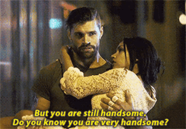 a man is holding a woman in his arms and says " but you are still handsome "