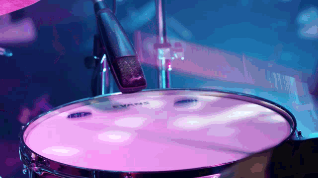 a drum with a evans drum head and a microphone in the background
