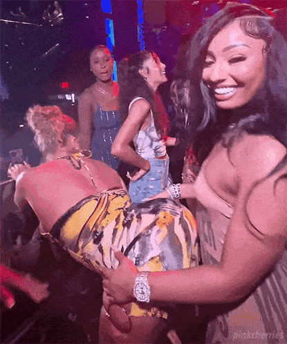 a group of women are dancing in a nightclub .