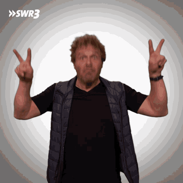 a man giving a peace sign with swr3 in the corner