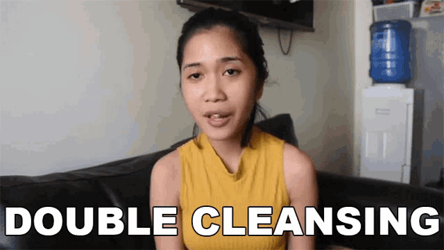 a woman sitting on a couch with the words double cleansing written on the screen