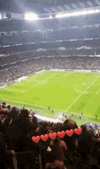 a soccer stadium with a lot of people and hearts in the stands