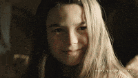 a close up of a young girl 's face with long blonde hair .