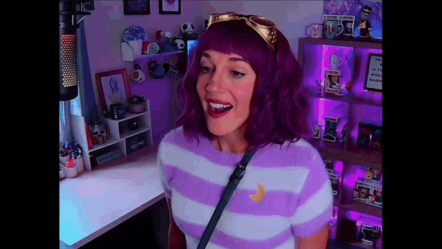 a woman with purple hair is wearing a striped shirt