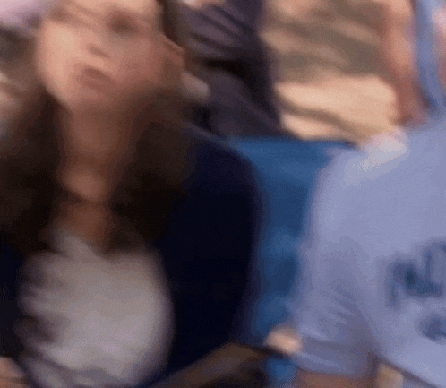 a blurry picture of a woman sitting in front of a group of people
