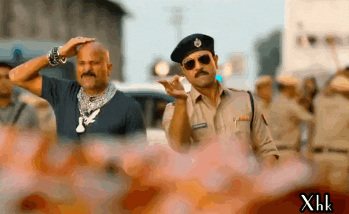a man in a police uniform salutes another man in a black shirt