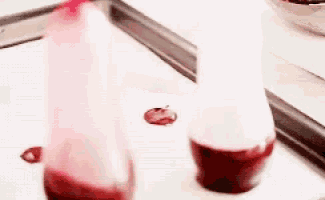 two bottles of red liquid on a table