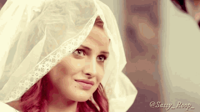 a woman wearing a white veil with the name sassy roop written on the bottom