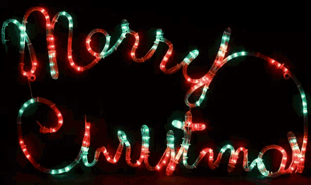 a sign that says merry christmas is lit up in the dark