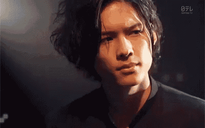 a close up of a man 's face with a black shirt on .