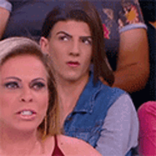a man and a woman are sitting next to each other in a row .