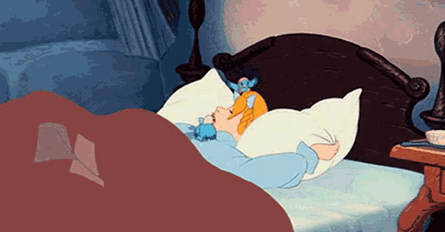 a cartoon of cinderella sleeping in a bed with a blue bird on her pillow .