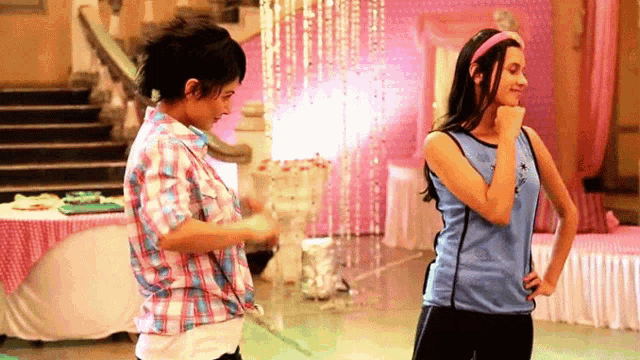 two girls are dancing in a room and one has a blue shirt with the word star on it