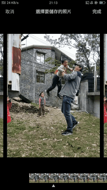 a phone screen shows a picture of a man holding a child in his arms
