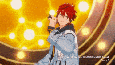 a man with red hair is singing into a microphone in front of a yellow background .