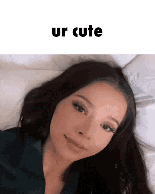 a woman laying on a bed with the words ur cute written above her