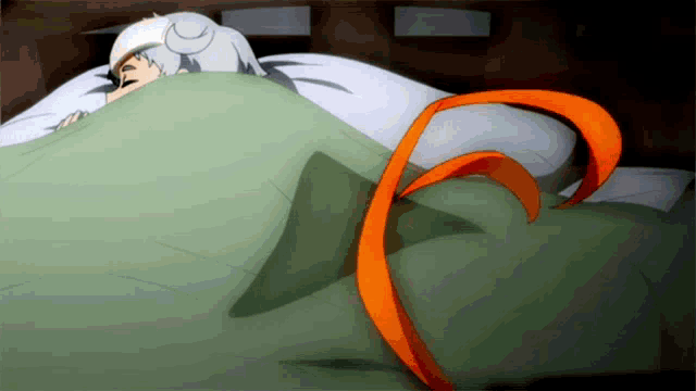 a person laying in bed with a green blanket