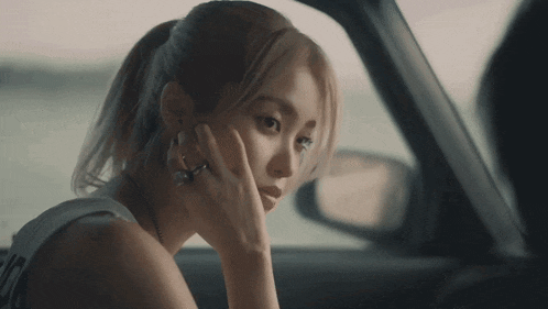 a woman sitting in a car looking out the window