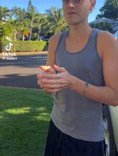 a woman in a tank top is standing in front of a car with tiktok written on the bottom right corner
