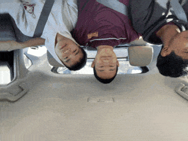 three men are sitting in a car with one wearing a shirt that says phoenix