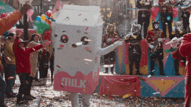a person in a milk carton costume stands in front of a crowd of people