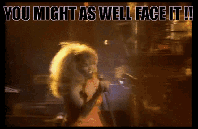 a woman singing into a microphone with the words " you might as well face it " below her