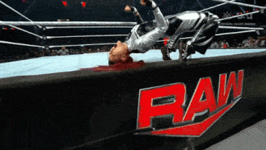 a female wrestler is laying on her back in front of a raw logo