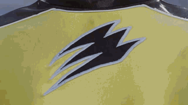 a close up of a person wearing a yellow and black shirt with a lightning bolt on it .