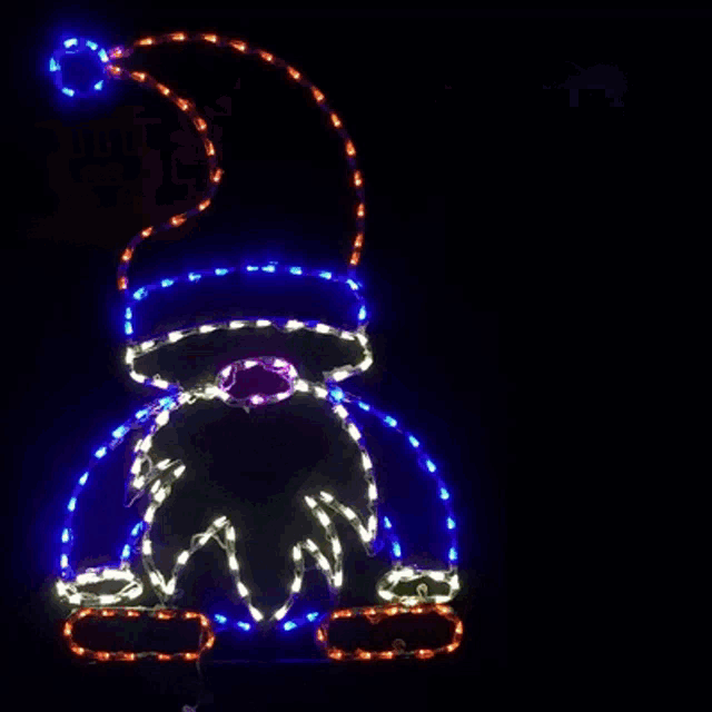 a silhouette of a witch with a broom is lit up with purple and green lights