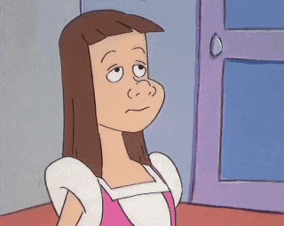 a cartoon girl with long brown hair is standing in front of a door and making a funny face .