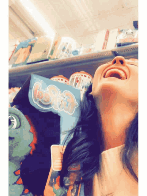 a woman is laughing in front of a sign that says ' lotta ' on it