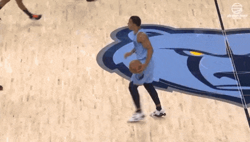 a basketball player is jumping in the air to catch a basketball while playing a game of basketball .
