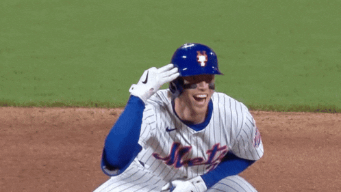 a mets baseball player wearing a blue helmet and white jersey