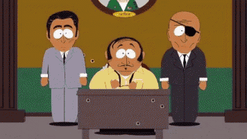 a man in a yellow shirt is sitting at a desk with two men standing around him