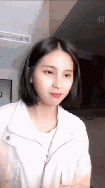 a woman wearing a white jacket and a white shirt