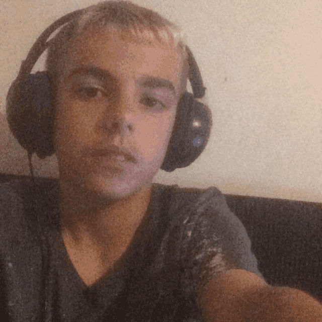 a young man wearing headphones and a grey shirt