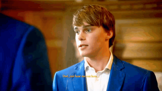 a man in a blue suit is talking to another man with the words dad just hear me out here below him