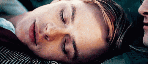 a close up of a man sleeping next to another man .