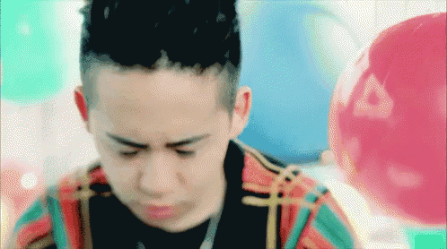 a close up of a person 's face with balloons behind him