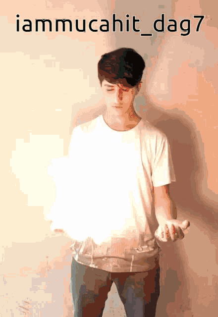 a man in a white shirt is holding something in his hands with the words iammucahit_dag7 written above him