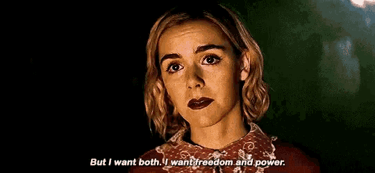 a woman is standing in a dark room and saying `` but i want both , i want freedom and power . ''
