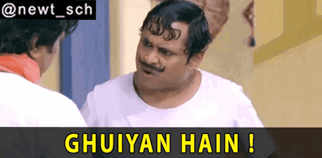 a man with a mustache is talking to another man with the words " ghuiyan hain " below him