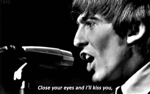 a close up of a man singing into a microphone with the words close your eyes and i 'll kiss you .