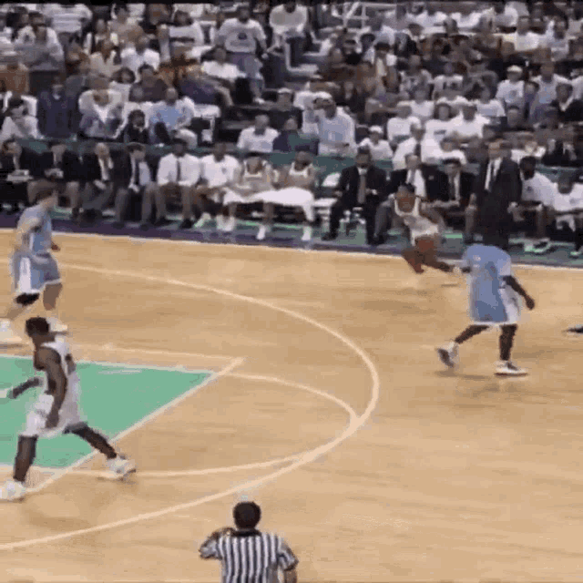 a basketball game is being played in front of a large crowd