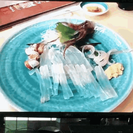 a close up of a plate of food on a table next to an lg tv