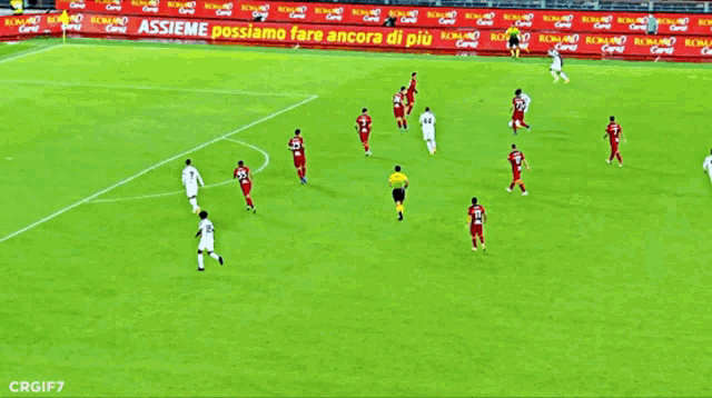 a soccer game is being played on a field with advertisements on the side of the field