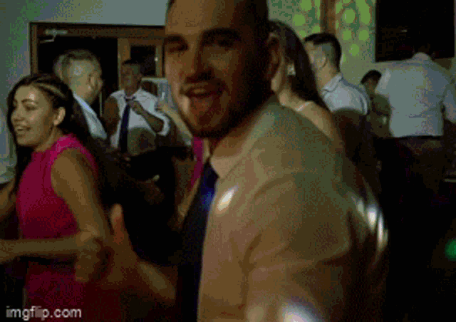 a man is giving a thumbs up while dancing at a party .