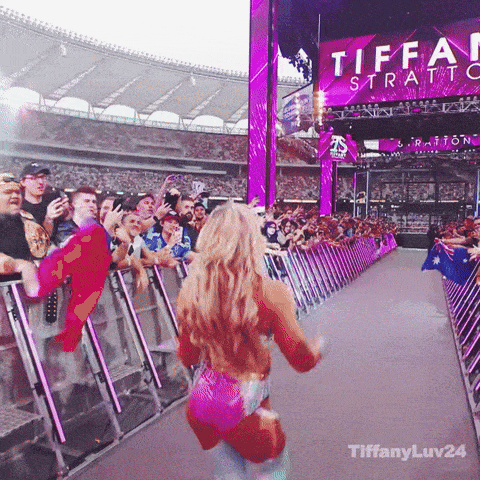 a woman in a pink outfit is dancing in front of a crowd at a tiffani stratford event