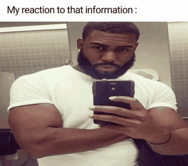 a man with a beard is taking a selfie in a bathroom with the caption " my reaction to that information "