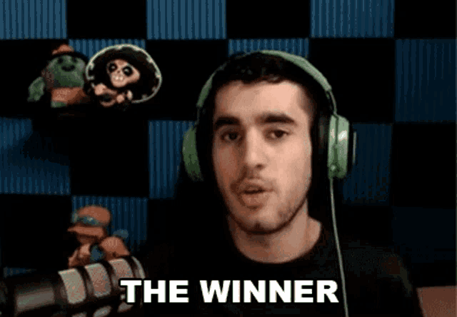 a man wearing headphones is sitting in front of a microphone and says `` the winner '' .